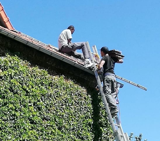 2 couvreurs sur un toit en rénovation